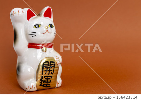 茶色背景に置かれた開運招き猫 136423514