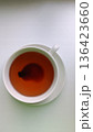 Close-up shot of a cup with traditional fermented Pu-erh tea. Clean white background highlights the deep color and simplicity. Ideal for themes of healthy lifestyle Asian cuisine and natural beverages 136423660