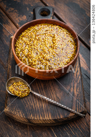 Dijon French mustard with grainy texture in wooden bowl flat lay on wooden background with copy space. Dijon French mustard with grainy texture in wooden bowl flat lay on wooden background with copy space. 136424806