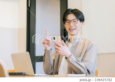 カフェでスマホを使うメガネをかけた男性 136425782