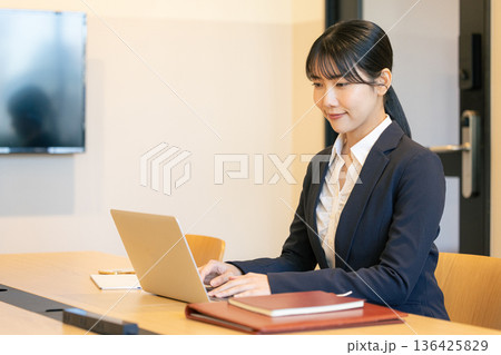 ノートパソコンを使って笑顔の若い女性 136425829