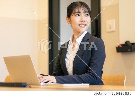 ノートパソコンを使って笑顔の若い女性 136425830