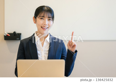 ノートパソコンを使って笑顔の若い女性 ノートパソコンを使って笑顔の若い女性 136425832
