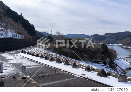 渇水であらわになった湖岸に雪が積もった奈良布目ダム　東端接道に積もった雪と布目湖 136427080