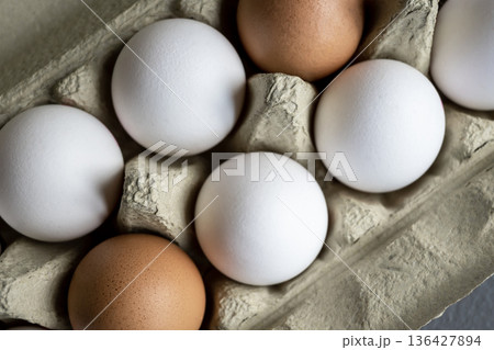 White and brown fresh eggs. Nature background. Chicken egg in carton box for cooking healthy food. Bio organic eggs on the farm. White and brown fresh eggs. Nature background. Chicken egg in carton box for cooking healthy food. Bio organic eggs on the farm. 136427894