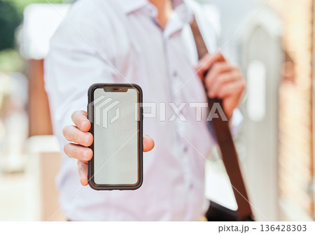Hand, phone and mockup with a business man in the city on his morning commute into work closeup. Mobile, app or communication with an employee showing blank space on a screen or display outdoor Hand, phone and mockup with a business man in the city on his morning commute into work closeup. Mobile, app or communication with an employee showing blank space on a screen or display outdoor 136428303
