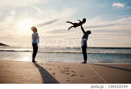 Family, beach and child in air with parents, sunshine with happiness and together with bonding on vacation. Travel, adventure and mother, father and kid flying, happy people in nature with silhouette Family, beach and child in air with parents, sunshine with happiness and together with bonding on vacation. Travel, adventure and mother, father and kid flying, happy people in nature with silhouette 136428344