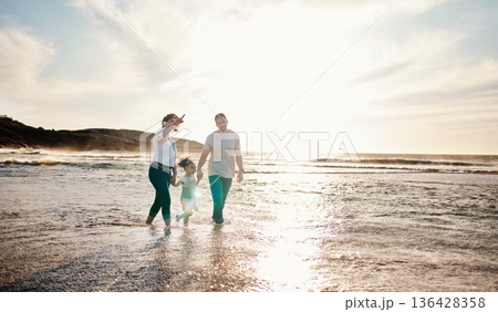 Beach, sunset and family holding hands together on vacation, adventure or holiday together. Travel, having fun and girl child bonding with mother and father on the sand by the ocean on weekend trip. Beach, sunset and family holding hands together on vacation, adventure or holiday together. Travel, having fun and girl child bonding with mother and father on the sand by the ocean on weekend trip. 136428358