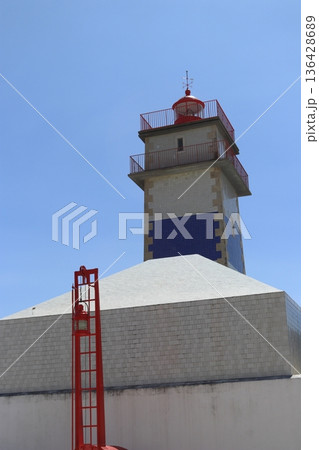 Close up view of the Santa Marta Lighthouse Farol de Santa Marta featuring its iconic blue and white tiled facade under a clear blue sky. 136428689