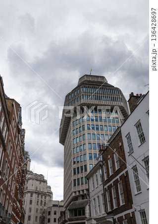 Tall government skyscraper between traditional brick buildings 136428697