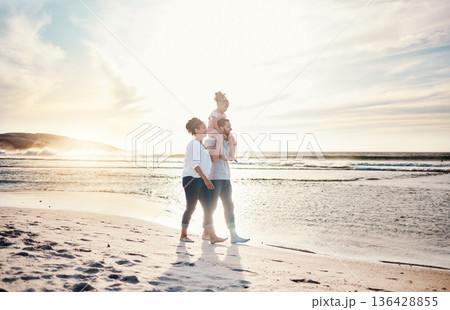Walking, sunset and family on the beach for vacation, adventure or holiday together for bonding. Travel, having fun and girl child with her mother and father on the sand by the ocean on weekend trip. Walking, sunset and family on the beach for vacation, adventure or holiday together for bonding. Travel, having fun and girl child with her mother and father on the sand by the ocean on weekend trip. 136428855