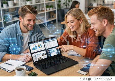 Three Colleagues Around Laptop Analyzing Dashboard And Revenue Charts, Discussing Targets And Strategy, Coffee Cups, Collaborative Planning Mood, Resultsfocused 136428902