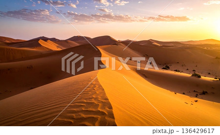 An orange sun sets over the red sand dunes of the Sahara, creating a hot wilderness landscape during a dry summer adventure in the arid Morocco desert An orange sun sets over the red sand dunes of the Sahara, creating a hot wilderness landscape during a dry summer adventure in the arid Morocco desert 136429617