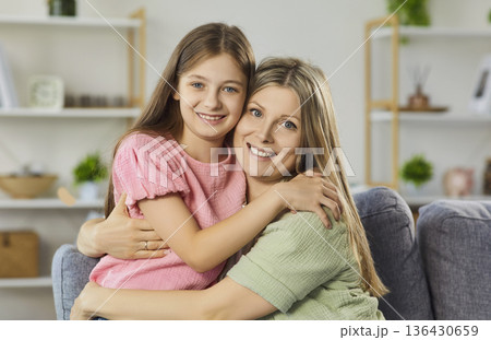 Happy mother hugging daughter at home, close bonding and positive emotions 136430659