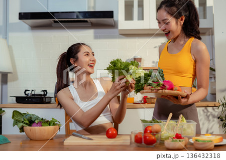Two sporty women drinking green smoothie and eating fresh vegetables. Two sporty women drinking green smoothie and eating fresh vegetables. 136432318