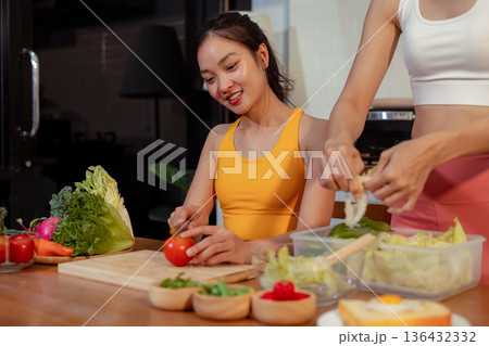 Two sporty women drinking green smoothie and eating fresh vegetables. Two sporty women drinking green smoothie and eating fresh vegetables. 136432332