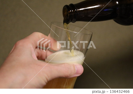 グラスにビールを注ぐ瞬間のクローズアップ　泡立つ黄金色のドリンク 136432466