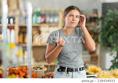 Thoughtful woman in a supermarket 136434033
