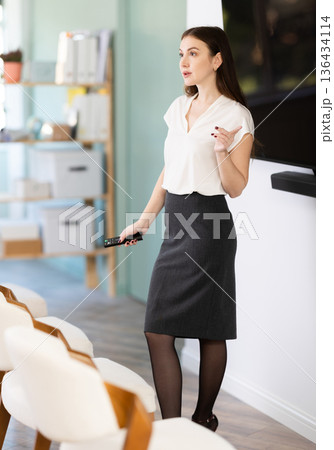 young woman in business clothes gives a presentation young woman in business clothes gives a presentation 136434114