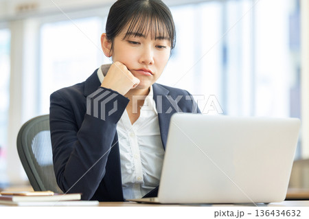 パソコンの画面を見ながら悩む女性 136434632