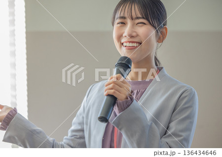 マイクを持って話す若い女性 マイクを持って話す若い女性 136434646