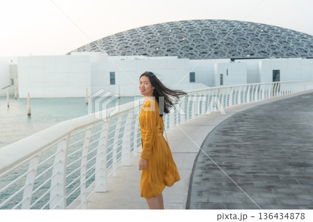 Fashionable Young Asian Woman in Yellow Outfit Outside Louvre Abu Dhabi United Arab Emirates 136434878