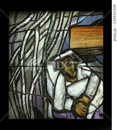 Simon of Cyrene carries the cross, detail of stained glass window by Sieger Koder in Chapel in the Jesuit cemetery in Pullach, Germany Simon of Cyrene carries the cross, detail of stained glass window by Sieger Koder in Chapel in the Jesuit cemetery in Pullach, Germany 136435300