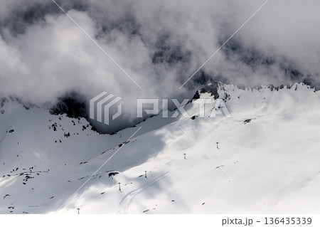 Dramatic winter landscape of Zugspitze mountain ridge covered in snow and heavy clouds. Dramatic winter landscape of Zugspitze mountain ridge covered in snow and heavy clouds. 136435339