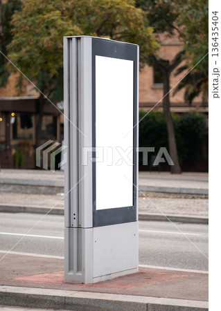 Blank vertical digital billboard mockup on city street, offering outdoor advertising space for marketing campaigns and public information displays Blank vertical digital billboard mockup on city street, offering outdoor advertising space for marketing campaigns and public information displays 136435404