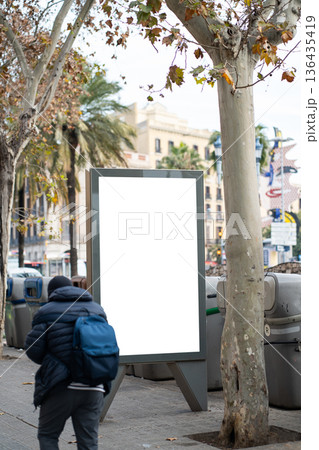 Outdoor blank billboard advertising mockup on an urban street with a person walking by, offering copy space for promoting products, services, or events in a city environment Outdoor blank billboard advertising mockup on an urban street with a person walking by, offering copy space for promoting products, services, or events in a city environment 136435419