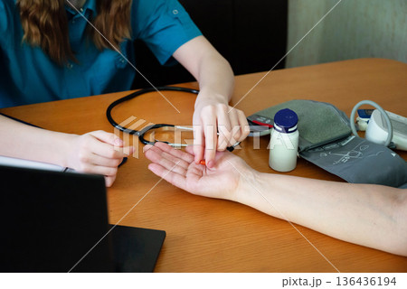 Health checkup involving patient consultation and medication advice at a medical office 136436194