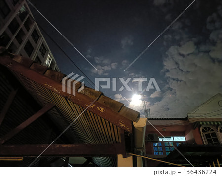 Night sky cloud moonlight urban rooftop house building cloud antenna cable window night 136436224