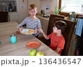 Two young boys sharing food at home, everyday childhood friendship moment 136436547