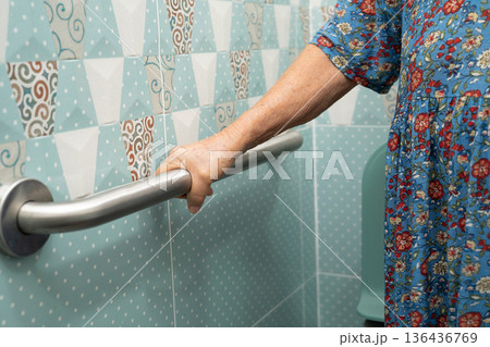 Asian elderly woman patient use toilet bathroom handle security in nursing hospital, healthy strong medical. 136436769