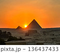 オレンジ色に染まる空とピラミッドのシルエット：古代の神秘を感じるギザの夕景 136437433