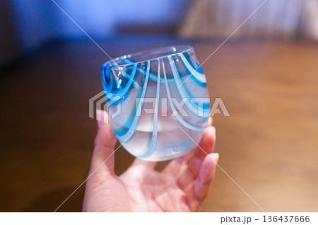 沖縄の琉球グラスを手に持つイメージ 136437666