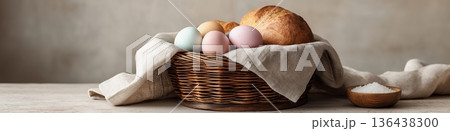 Wicker basket holding Easter food, colored eggs, bread, and salt. Easter wallpaper. Wicker basket holding pastel colored Easter eggs, bread, and salt on a simple background Wicker basket holding Easter food, colored eggs, bread, and salt. Easter wallpaper. Wicker basket holding pastel colored Easter eggs, bread, and salt on a simple background 136438300