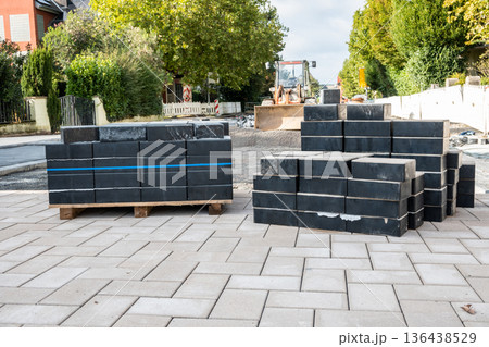 Pavement tiles for road sidewalk repair and bulldozer with backhoe. Construction process and urban infrastructure in big city. 136438529