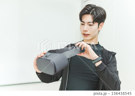 男性がVRヘッドセットを持つ 136438545