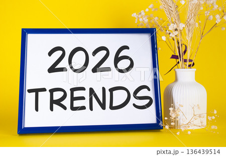 2026 Trends symbol. Concept words 2026 Trends on beautiful wooden picture frame. Beautiful yellow background with flower vase. Business and 2026 Trends concept. Copy space. 136439514