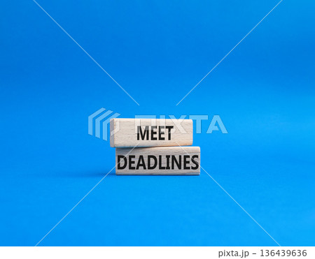Meet Deadlines symbol. Concept word Meet Deadlines on wooden blocks. Beautiful blue background. Business and Meet Deadlines concept. Copy space 136439636