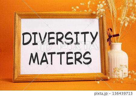 Diversity matters symbol. Concept words Diversity matters on beautiful wooden picture frame. Beautiful orange background with flower vase. Business and Diversity matters concept. Copy space. 136439713