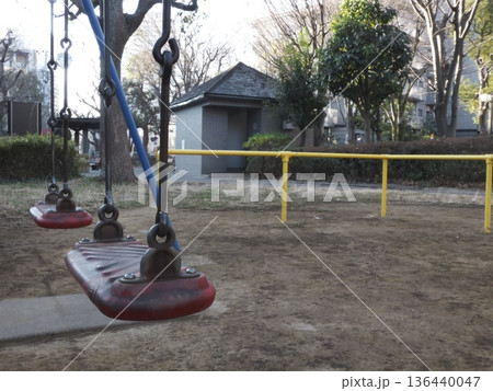 冬の公園の静かな風景と赤いブランコの座面 136440047