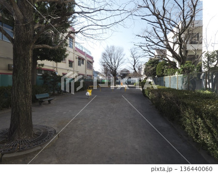 冬の柔らかな光が差し込む静かな住宅街の公園と遊具の風景 136440060
