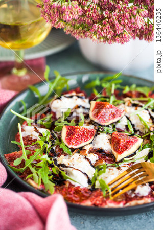 Delicious fresh fig carpaccio with burrata or stracciatella or mozzarella cheese and arugula salad 136440235
