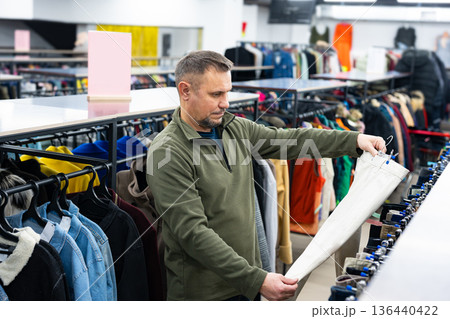 Man browsing clothes at vintage thrift shop, second-hand stylish store 136440422