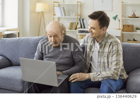 Senior with laptop computer, grown-up son, adult grandson and old father learning how to use app 136440629