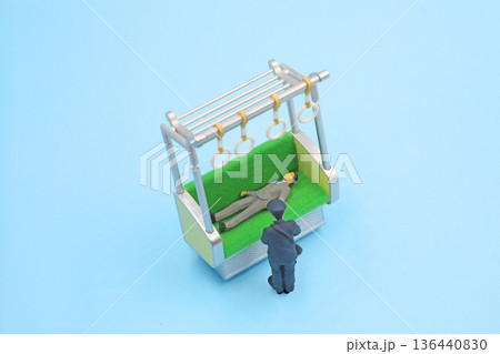 酔っぱらって寝ている乗客を起こす駅員さん 136440830