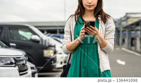 駐車場でスマホ操作する女性 ■撮影協力:関西国際空港(KIX) 駐車場でスマホ操作する女性 ■撮影協力:関西国際空港(KIX) 136441098