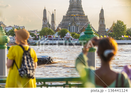 Tourists take photos with their smartphones at Wat Arun Ratchawararam Ratchaworamahawihan during sunset in Bangkok, Thailand. Tourists take photos with their smartphones at Wat Arun Ratchawararam Ratchaworamahawihan during sunset in Bangkok, Thailand. 136441124